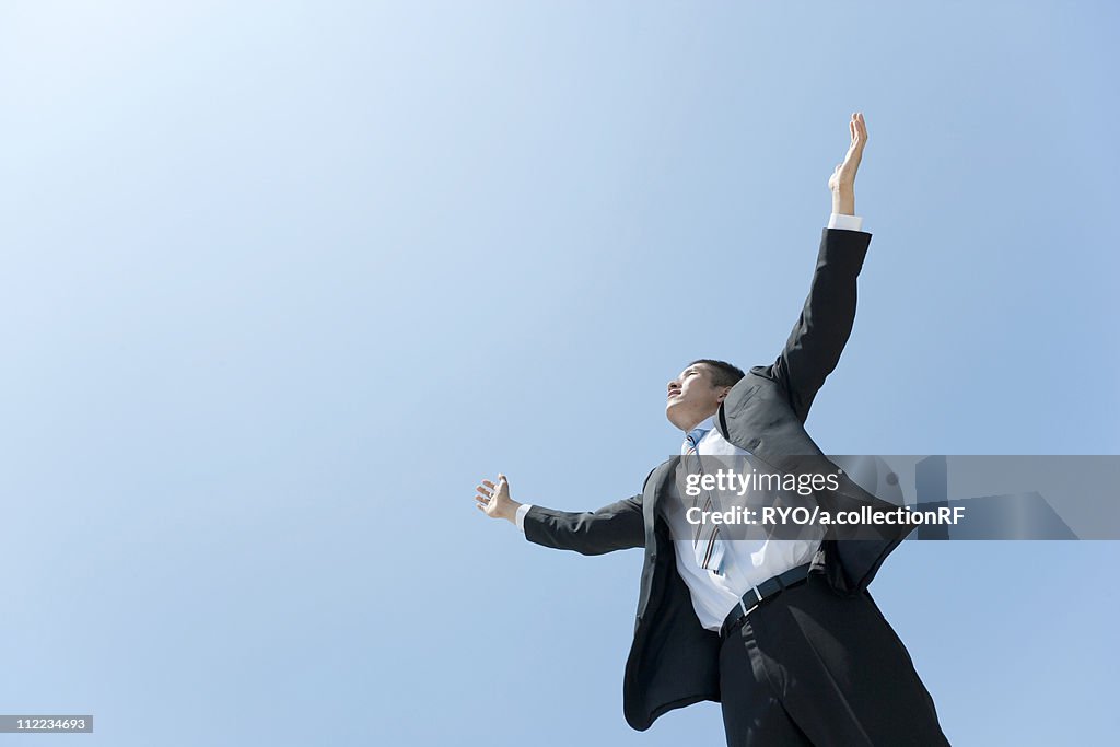 A businessman opening hands up to the sky
