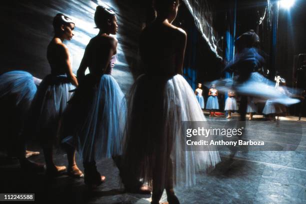 View of ballet dancers from the Dance Theatre of Harlem, in costume and rehearsing on stage, New York, 1983.
