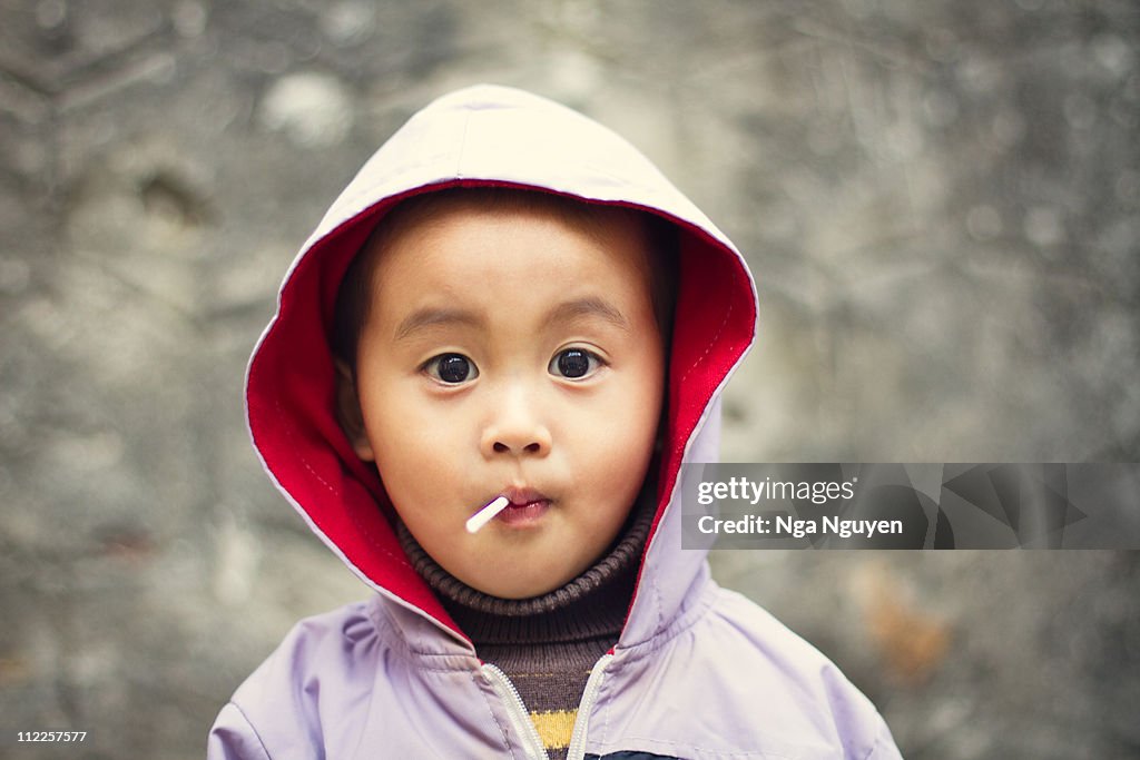 Toddler boy eating lollipop