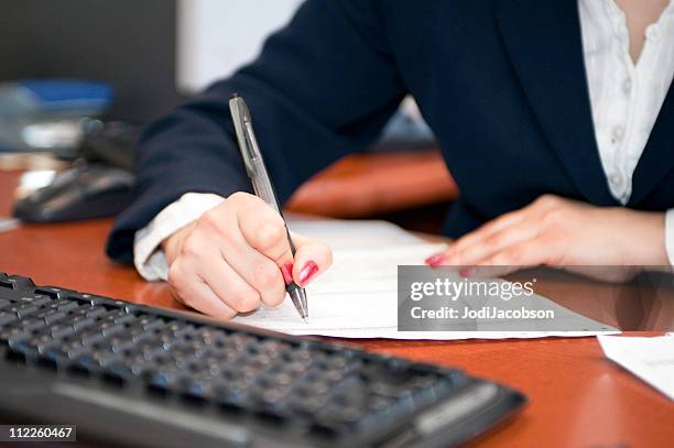 businesswoman filling out contract - credit report stockfoto's en -beelden