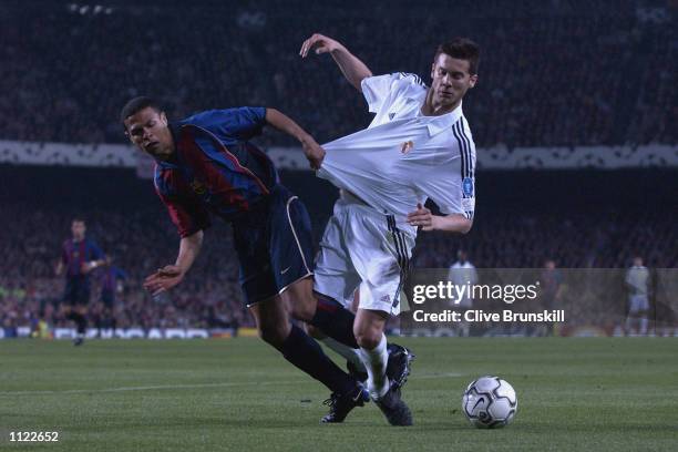 Solari of Real Madrid has his shirt pulled by Geovanni of Barcelona during the Barcelona v Real Madrid Champions League semi-final, first leg at the...