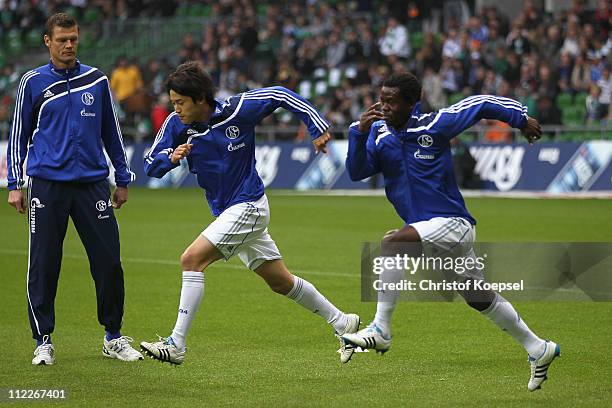 Atsuto Uchida of Schalke and Anthony Annan of Schalke run prior to the Bundesliga match between SV Werder Bremen and FC Schalke 04 at Weser Stadium...