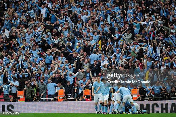 The City fans celebrate after Yaya Toure of Manchester City scored the opening goal during the FA Cup sponsored by E.ON semi final match between...