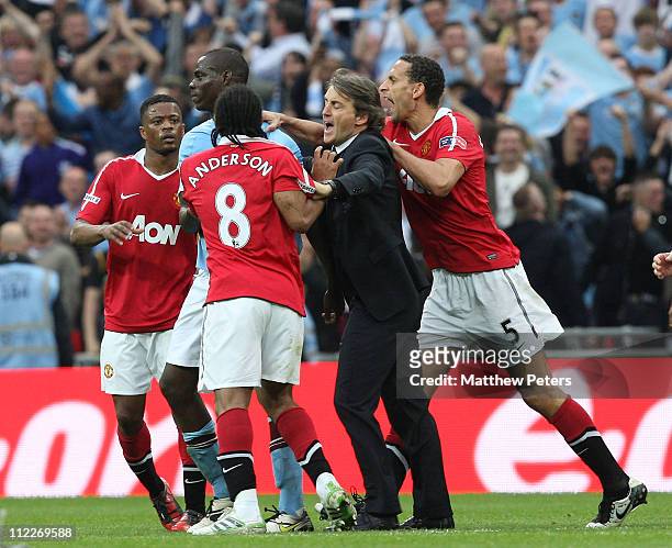 Rio Ferdinand of Manchester United and Roberto Mancini of Manchester City intervene as Anderson of Manchester United clashes with Mario Balotelli of...