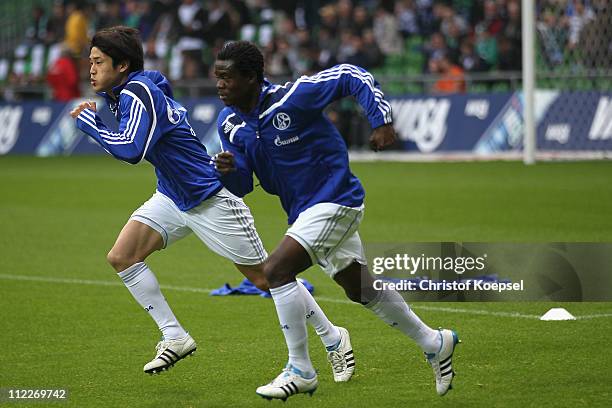 Atsuto Uchida of Schalke and Anthony Annan of Schalke run prior to the Bundesliga match between SV Werder Bremen and FC Schalke 04 at Weser Stadium...
