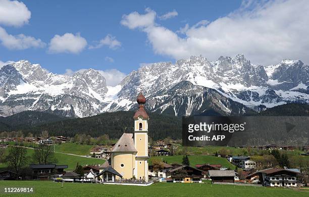 The church Pfarrkirche zum Heiligen Kreuz in front of the Alps mountains Wilder Kaiser in Going, Austria, pictured ahead the wedding ceremony of...