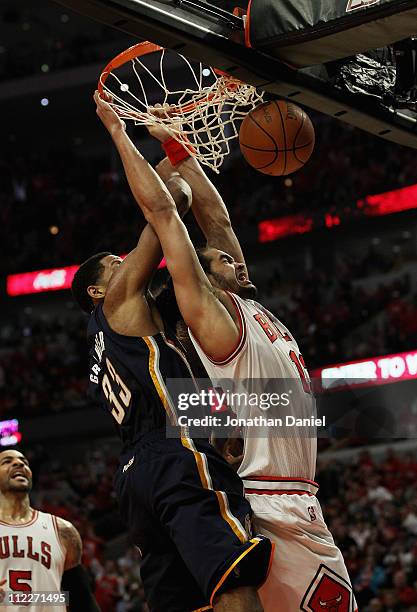 Joakim Noah of the Chicago Bulls dunks the ball and is fouled by Danny Granger of the Indiana Pacers in Game One of the Eastern Conference...