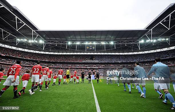 The teams walk out during the FA Cup sponsored by E.ON semi final match between Manchester City and Manchester United at Wembley Stadium on April 16,...