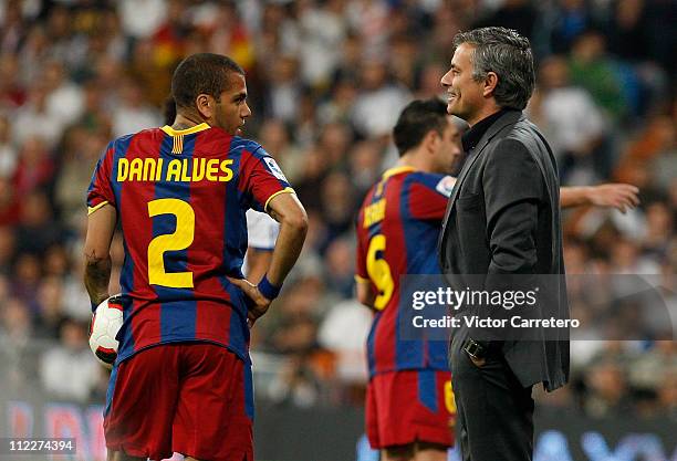 Head coach Jose Guardiola of Real Madrid smiles beside Daniel Alves of Barcelona during the La Liga match between Real Madrid and Barcelona at...