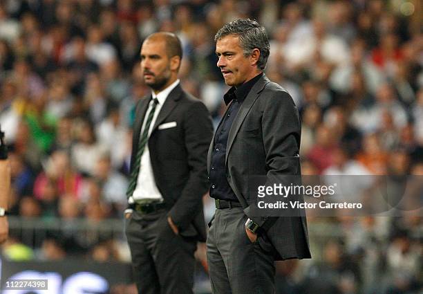Head coach Jose Mourinho of Real Madrid looks on backdropped by head coach Josep Guardiola of Barcelona during the La Liga match between Real Madrid...