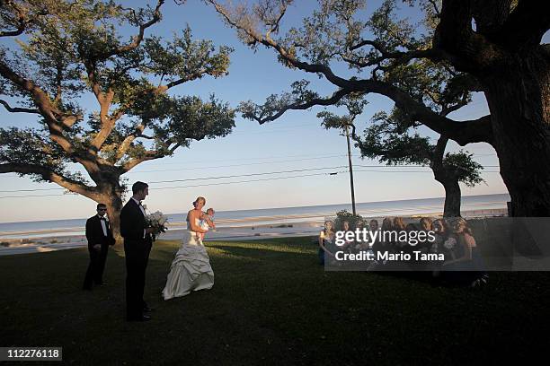 Bride Amanda Benvenutti walks during a photo session above the beach after her wedding April 16, 2011 in Waveland, Mississippi. Waveland's beaches...