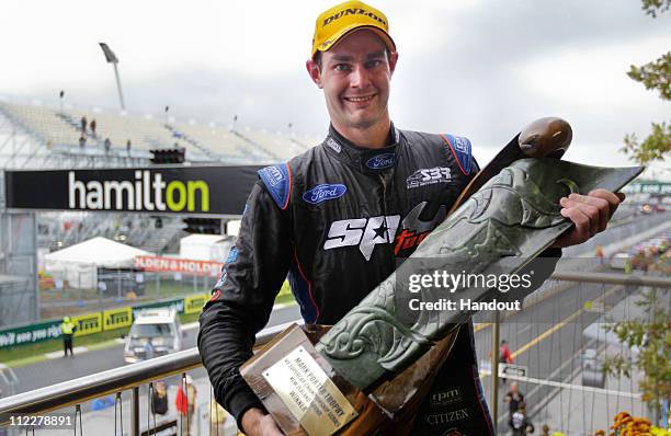 In this handout photo provided by Mark Horsburgh, Shane Van Gisbergen driver of the SP Tools Racing Ford holds the winners trophy after winning race...