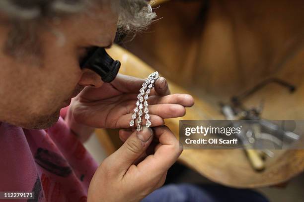 Garrard jeweller examines a diamond earring in the workshop of Garrard's flagship store in Mayfair on April 6, 2011 in London, England. Garrard is...