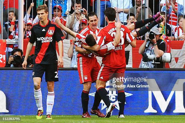 Franck Ribery of Muenchen celebrates his team's fifth goal with team mates Miroslav Klose and Mario Gomez as Daniel Schwaab of Leverkusen reacts...