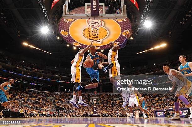 Jarrett Jack of the New Orleans Hornets looks to pass between Andrew Bynum and Lamar Odom of the Los Angeles Lakers in Game One of the Western...