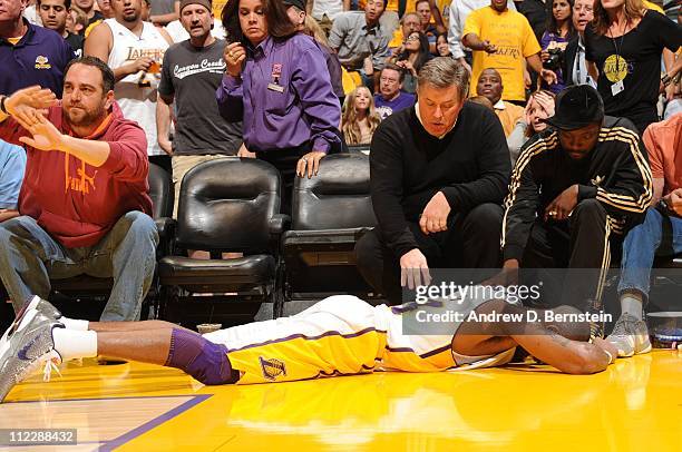 Kobe Bryant of the Los Angeles Lakers lies on the floor after falling into a row of courtside seats against the New Orleans Hornets in Game One of...