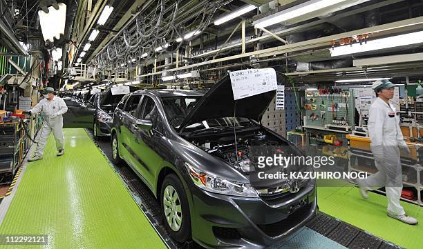 Honda Motor's workers assemble a body of the company's latest vehicles on the assembly line at the Sayama factory in Saitama prefecture on April 18,...