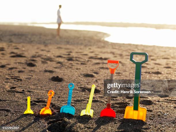 row of assorted plastic spades standing in sand - 数個の物 ストックフォトと画像