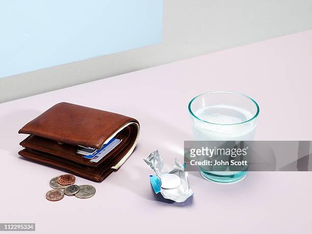 wallet with headache tablet and glass of water - brieftasche stock-fotos und bilder