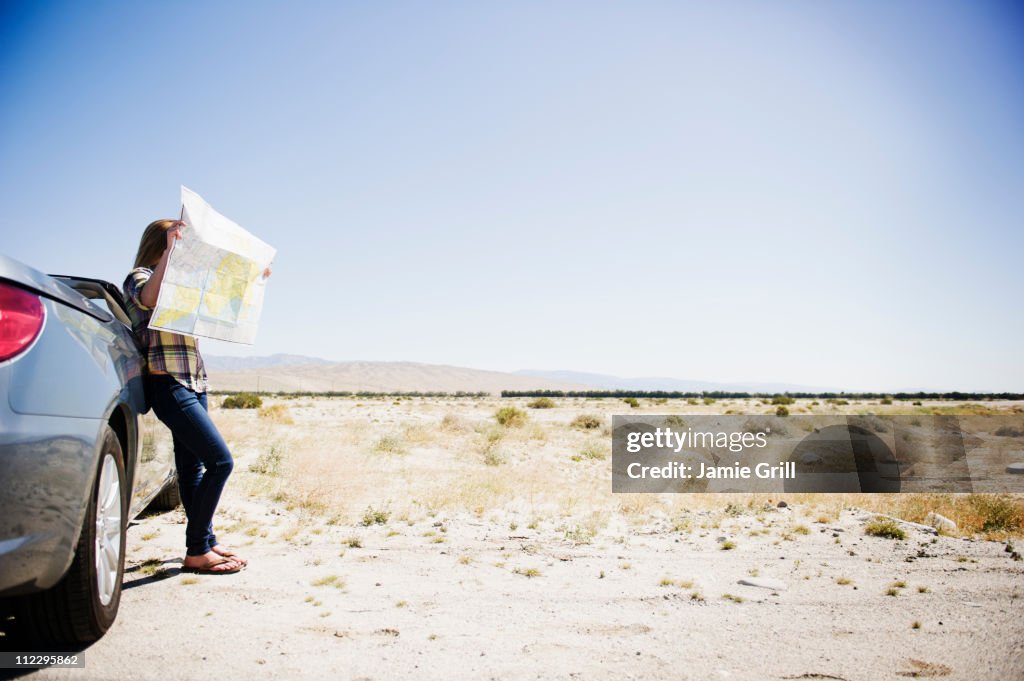Woman looking at map on side of road
