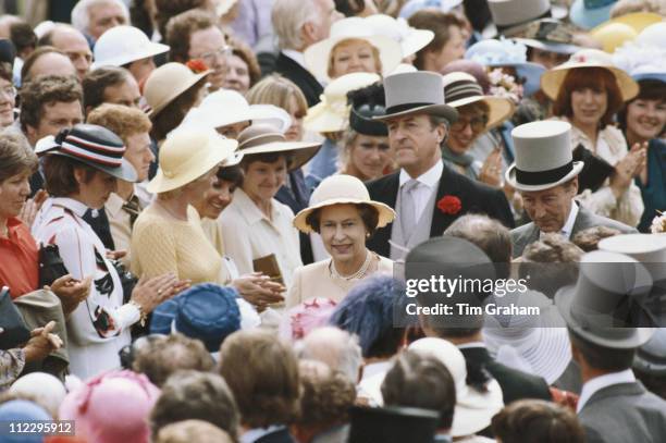 Queen Elizabeth II , with her bodyguard, Commander Michael Trestrail, walking through the crowds at the Royal Ascot race meeting, at Ascot racecourse...