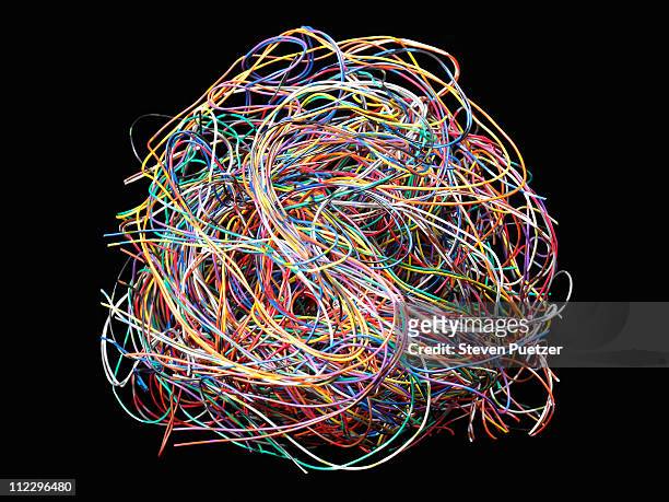 tangled ball of colored wires against black - complessità foto e immagini stock