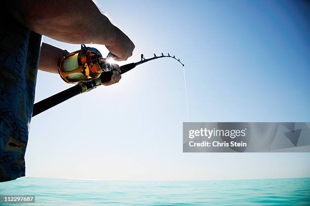 man fishing on the open water - fishing rod stock pictures, royalty-free photos & images