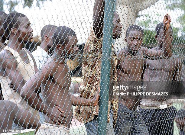 Arrested militiamen loyal to Laurent Gbagbo stand on the tennis court of the Golf Hotel in Abidjan on April 13, 2011. Ivory Coast President Alassane...
