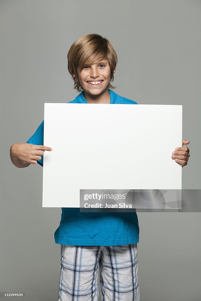 Boy holding a blank whiteboard, smiling, portrait
