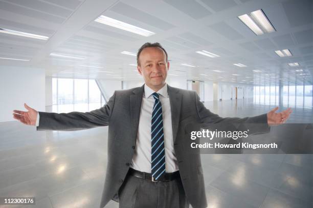 male executive standing with arms outstretched in - arms outstretched stock pictures, royalty-free photos & images