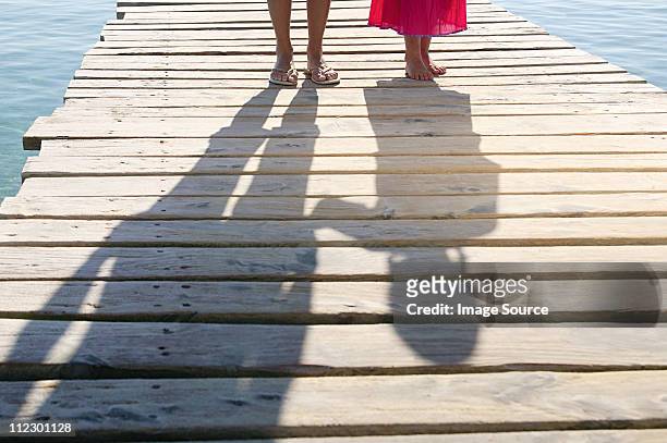shadows of child and adult on jetty - palma mallorca stock-fotos und bilder