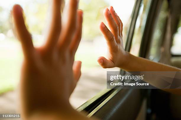 enfant mains toucher fenêtre de la voiture - embuscade photos et images de collection