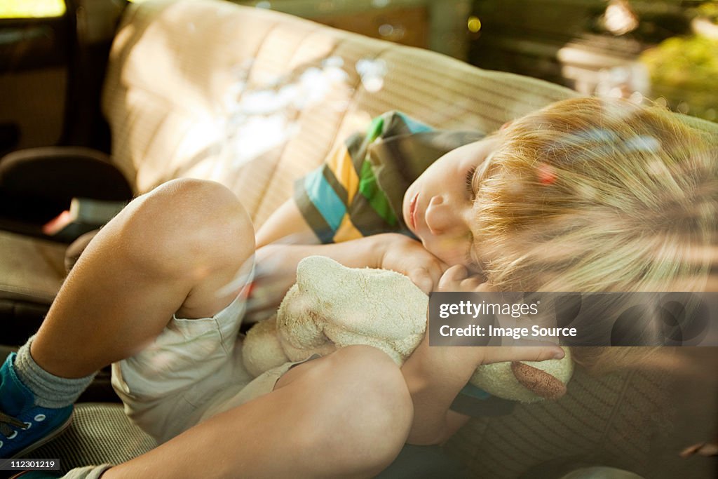 Boy asleep in back seat of car