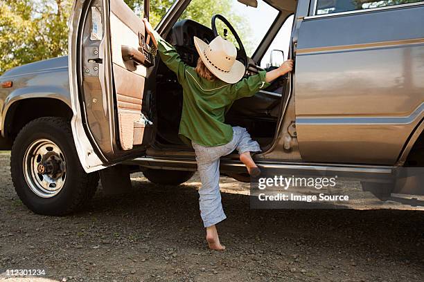 boy in cowboy hat, climbing into station wagon - station wagon stock pictures, royalty-free photos & images