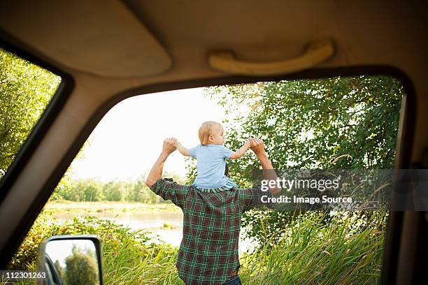 father with son on shoulders, viewed from a car - holding hands in car stock pictures, royalty-free photos & images