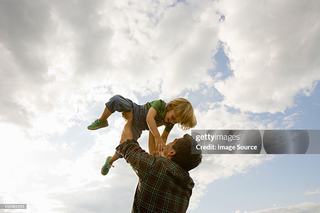 Father lifting son up to the sky