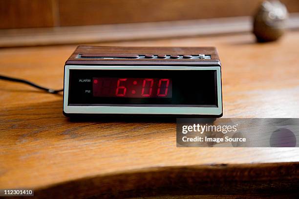 digital alarm clock showing 6.00am - awake day stockfoto's en -beelden