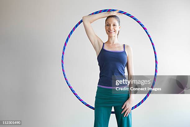 woman holding plastic hoop doing pilates - hula hoop studio stock pictures, royalty-free photos & images