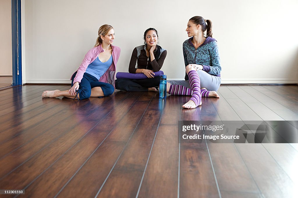 Three women sitting on gym floor