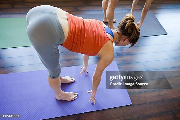 two women doing yoga class - female derriere stockfoto's en -beelden