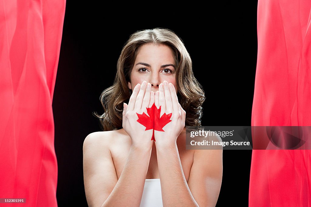 Woman with maple leaf painted on hands