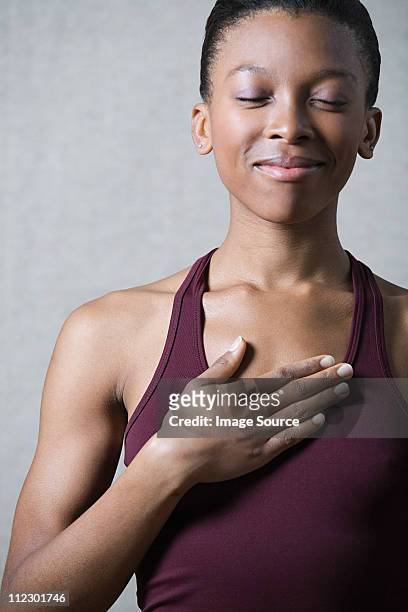 women breathing deeply, touching chest - hand on chest stock-fotos und bilder