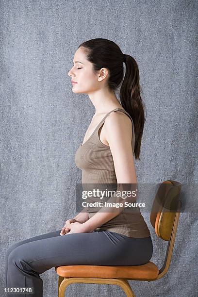 women sitting on chair, eyes closed - yoga chair stockfoto's en -beelden