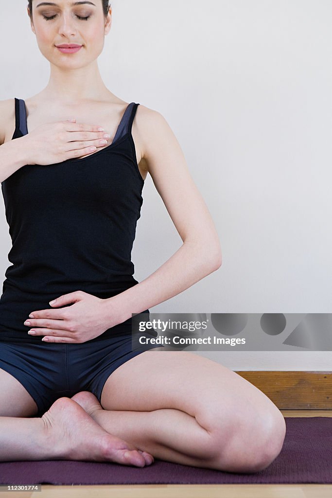 Women breathing deeply, touching chest and abdomen