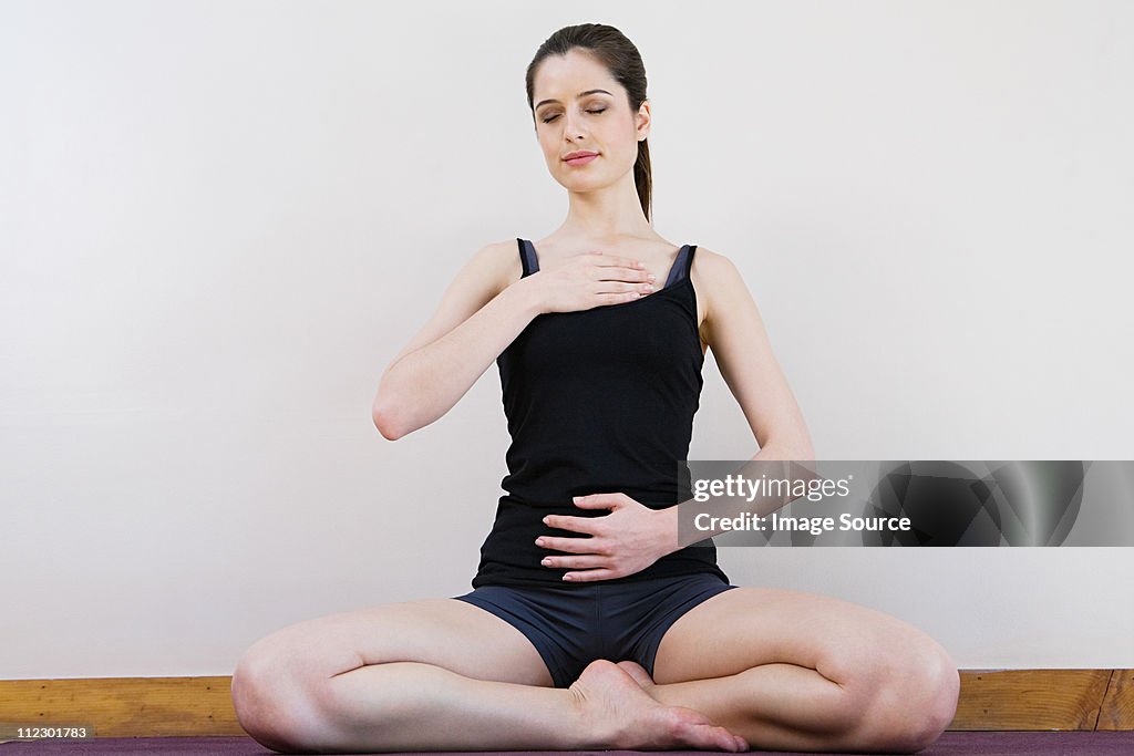 Women breathing deeply, touching chest and abdomen