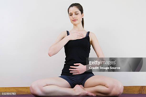 women breathing deeply, touching chest and abdomen - inhaling stockfoto's en -beelden
