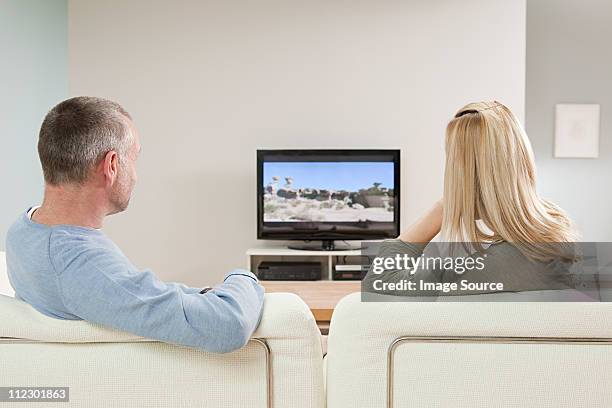 couple watching television - back of sofa stock pictures, royalty-free photos & images