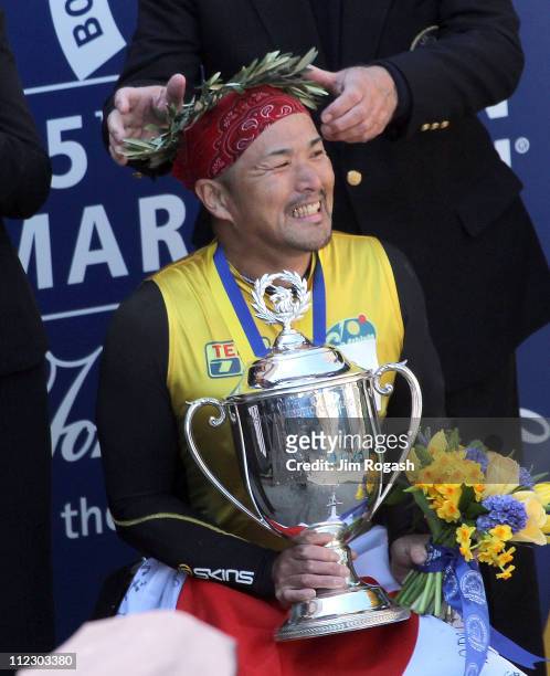 Masazumi Soejima of Japan holds the trophy after winning the men's wheelchair division of the 115th running of the Boston Marathon on April 18, 2011...