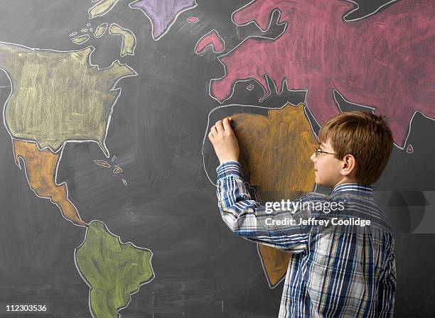 child drawing world map on blackboard - left hand stock pictures, royalty-free photos & images