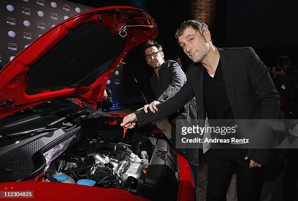 Actors Heikko Deutschmann and Ingo Naujoks pose at the Volkswagen New Beetle during the world premiere of the 21st Century Beetle at ewerk on April...